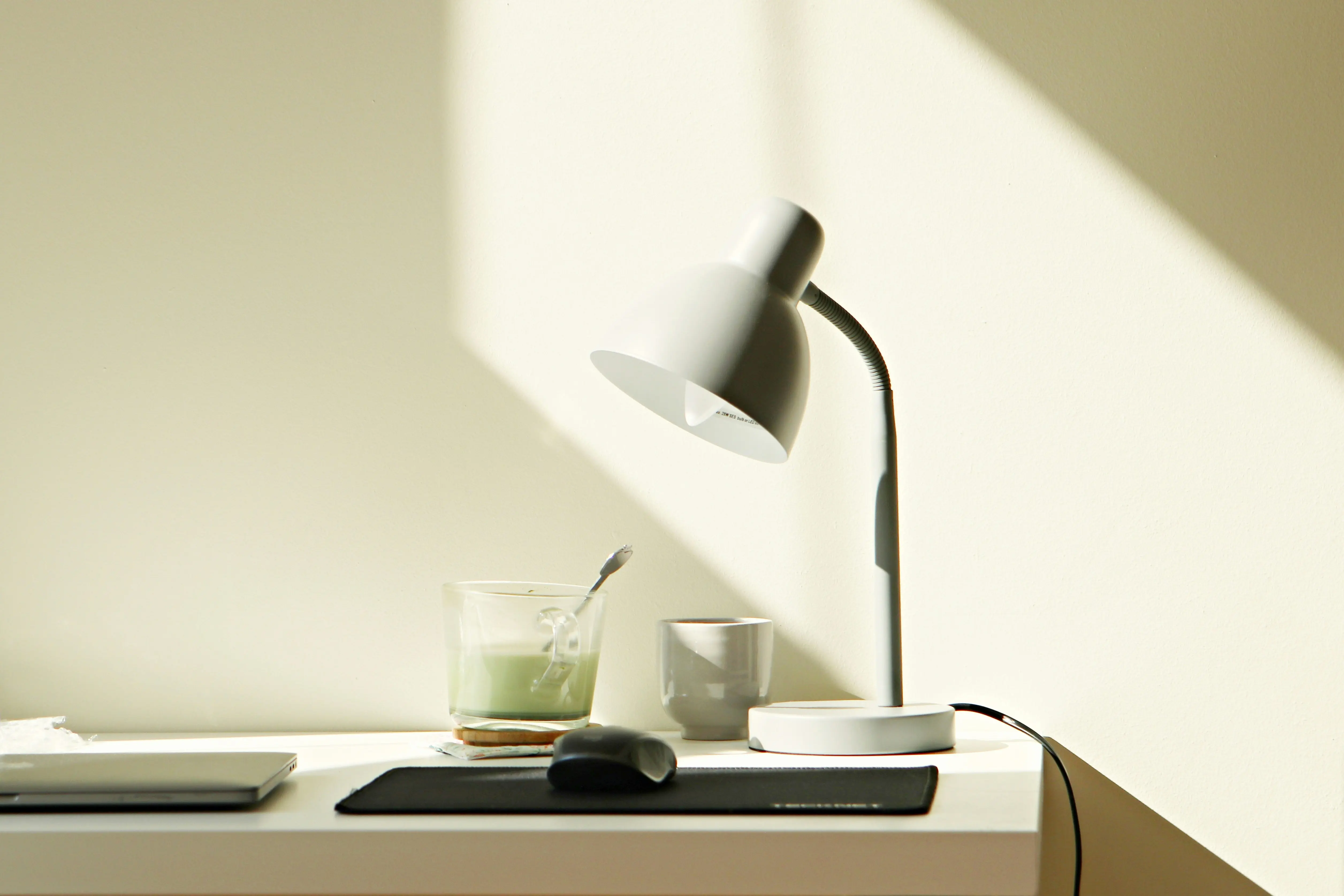 Lampe de bureau et plan de travail épuré, lumière rasante